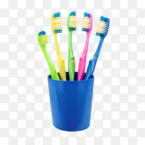蓝色塑料杯子里的一排牙刷实物-空若网 蓝色塑料杯子里的一排牙刷实物-空若网